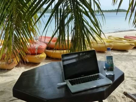 A laptop in the table with the sea background