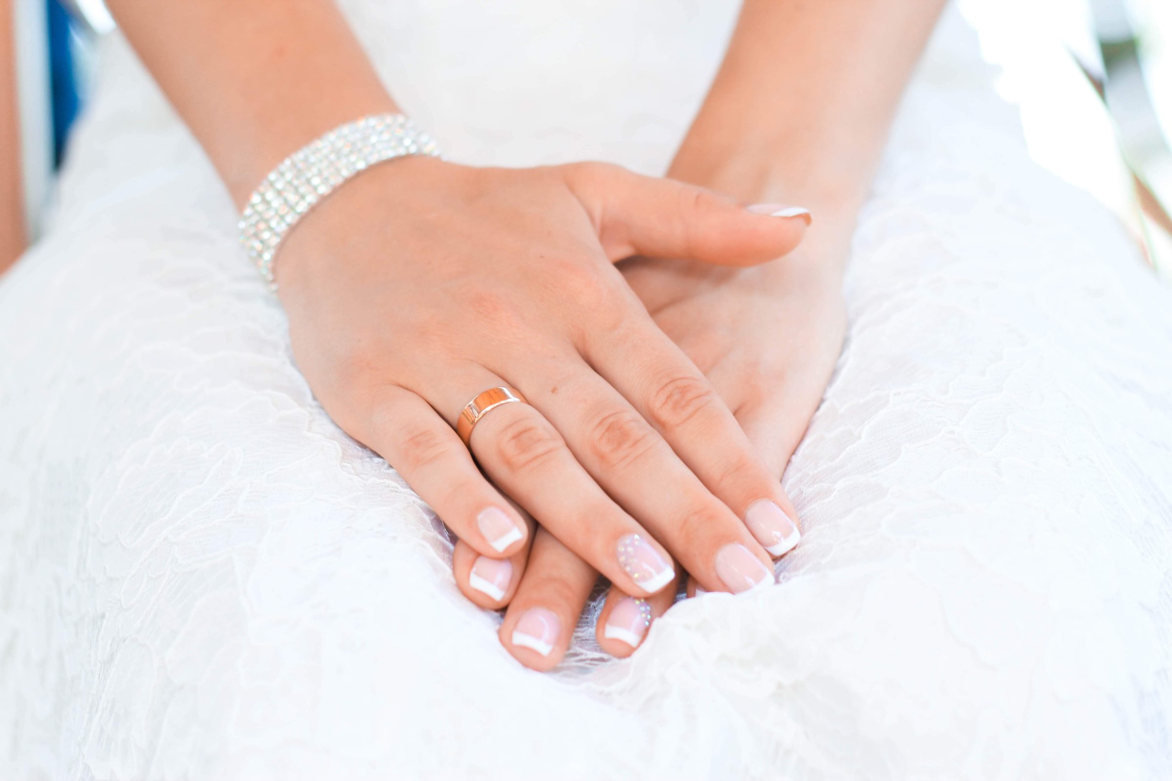 A bride hand with white dress and a ring