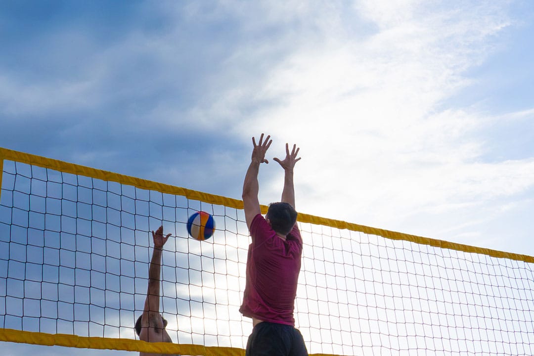 Men playing volleyball.