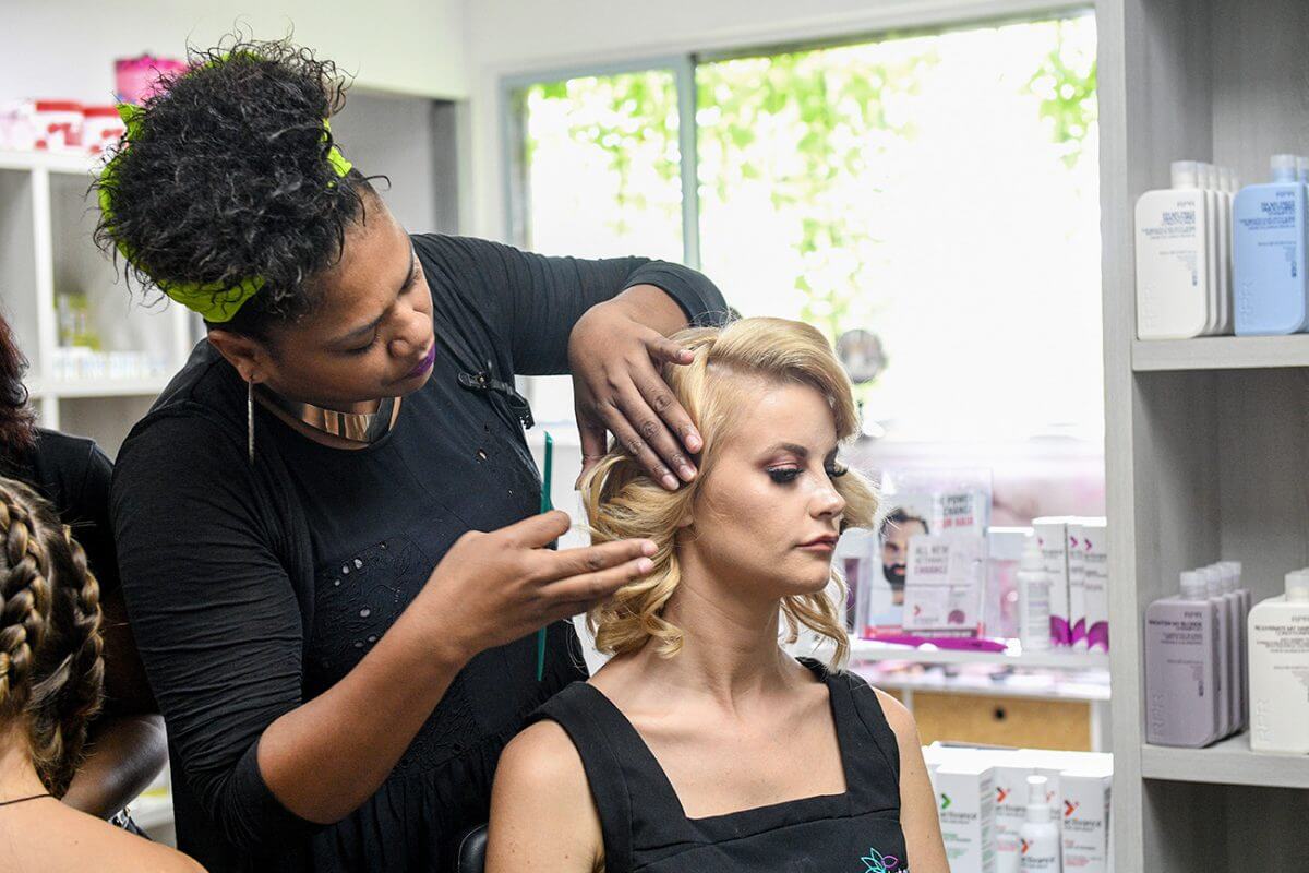 A woman artist preparing for hair and make up to the other woman