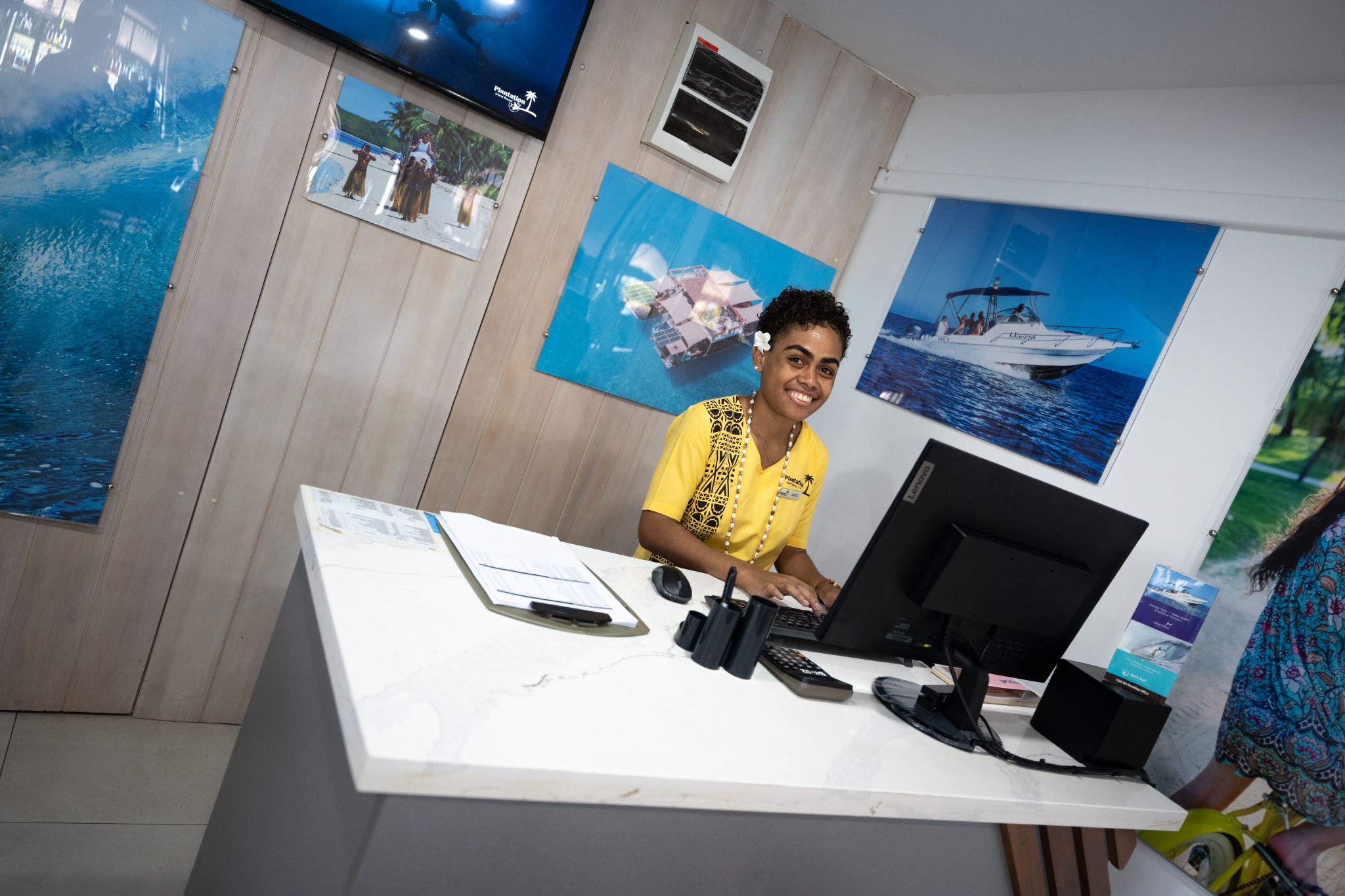 A woman at the desk smiling typing the keyboards.